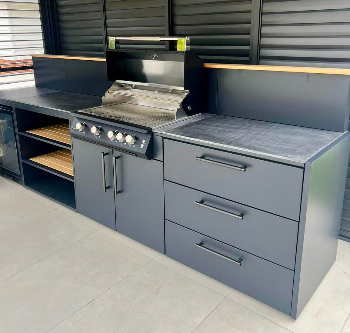 Sort udekøkken med køleskab og gasgrill
